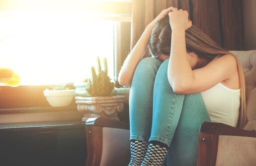 A woman lies asleep on a couch, exhibiting the characteristics of a broken person.