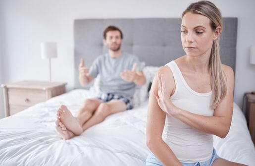 Silhouette of a couple standing apart against a sunset, symbolizing the dilemma of staying in an unhappy marriage