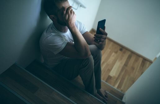 The image depicts a man and woman sitting on a bed, with the man's facial expression conveying a sense of longing and sadness, possibly due to missing his ex-wife